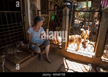 Kandy, Sri Lanka. Il 21 febbraio, 2018. EVA RUPPEL siede alla sua porta anteriore sulla sua proprietà rurale vicino a Kandy, Sri Lanka, mercoledì 21 febbraio, 2018. Ruppel non gabbia /-170 cani ha salvato, consentendo loro la libertà per interagire in piccole confezioni di penne multiple in tutta la sua proprietà, come pure all'interno di lei a casa. Ruppel creato Tikiri Trust, con il contributo finanziario di suo padre, di salvataggio e rehome Sri Lanka di cani randagi.It è possibile visitare lo Sri Lanka senza vedere i cani di strada in quasi ogni spazio pubblico, vicino ad alberghi, pensioni e ristoranti, scuole, uffici, Foto Stock