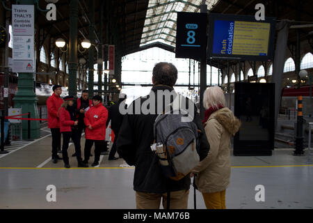 Paio di attendere per informazioni circa il loro viaggio dopo i treni sono annullati a causa di treno colpisce, Gare de Nord, Paris, Francia Foto Stock