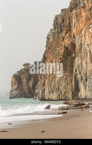 Paesaggio con roccia sulla spiaggia sabbiosa. Composizione verticale. Foto Stock