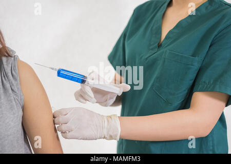 Close-up mani,infermieri sono le vaccinazioni a pazienti utilizzando la siringa.medico la vaccinazione di donne in ospedale.sono trattati mediante l'uso di iniettabili sterili Foto Stock