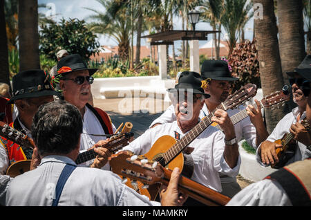 Puerto de la Cruz Tenerife Isole Canarie - Maggio 30, 2017: Canarie persone vestite con abiti tradizionali a piedi lungo la strada, firmare e a suonare la chitarra Foto Stock