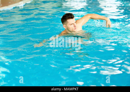 Uomo bello nuotare in piscina Foto Stock