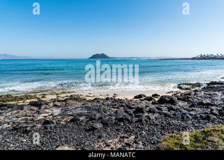 Spiaggia di Corralejo Bay al mattino contro il cielo blu con Isola di Lobos e Lanzarote sullo sfondo Foto Stock