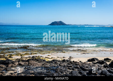 Spiaggia di Corralejo Bay al mattino contro il cielo blu con Isola di Lobos e Lanzarote sullo sfondo Foto Stock