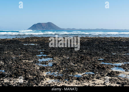 Spiaggia di Corralejo Bay al mattino contro il cielo blu con Isola di Lobos sullo sfondo Foto Stock