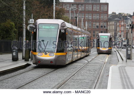 Due tram Luas tirare in su una piattaforma vicino a St Stephen's Green in una fredda giornata piovosa come Dublino città interna diventa sempre più accessibile tramite il tram. Foto Stock