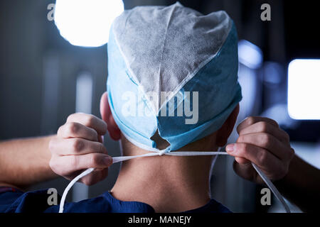 Chirurgo di legatura cappuccio chirurgica in preparazione, vista posteriore Foto Stock