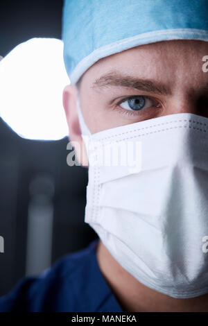 Maschio lavoratore del settore sanitario in scrubs colpo alla testa, ritagliata verticale Foto Stock