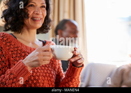 Donna di mezza età incontro con gli amici intorno al tavolo In Coffee Shop Foto Stock