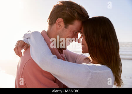 Coppia romantica a camminare lungo la spiaggia invernale insieme Foto Stock