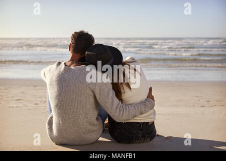 Coppia romantica seduto sulla Spiaggia Invernale insieme Foto Stock