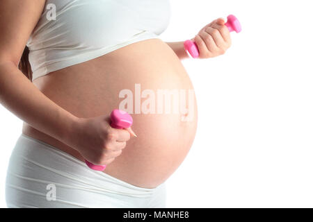 Donna incinta che lavora fuori con manubri Foto Stock