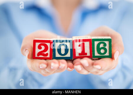 Business per la piallatura 2016. Cubi di legno 2016 nella donna la mano vicino fino Foto Stock