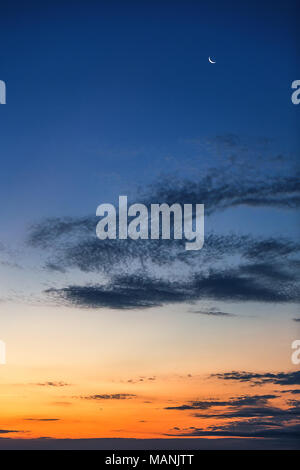 Bellissimo tramonto romantico, la luna e le stelle luminose nel cielo colorato. Foto Stock