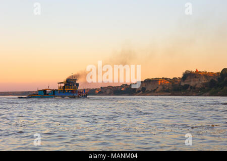 Una piccola barca da pesca sul fiume Irrawaddy al tramonto. Nyaung U, Myanmar (Birmania). Foto Stock