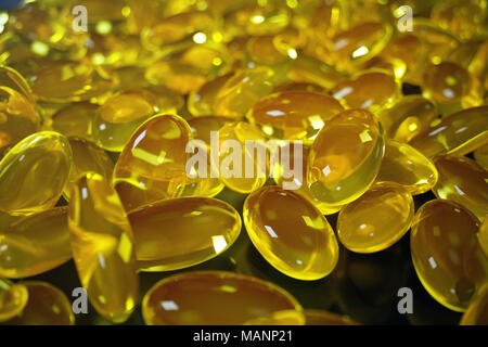 Il rendering 3D'olio di pesce. Omega 3, omega 6 e omega 9, vitamina D. pila di capsule di Omega 3 su sfondo nero, di fegato di merluzzo Foto Stock