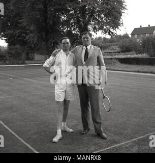 1954, storico, due uomini posano per una foto in piedi su un erba-court tennis al Bonham-Carter's country-house, Wyck Place, vicino a Alton, Hampshire, Inghilterra, Regno Unito. Foto Stock