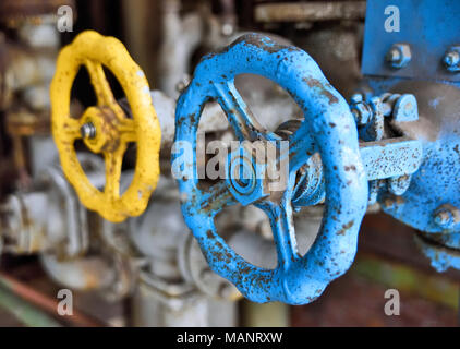 Vecchia industria valvola e tubi. Rusty valvola rotativa e tubi in una fabbrica abbandonata. Foto Stock