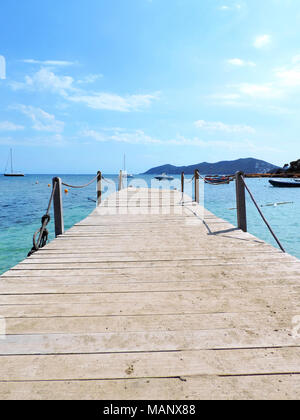 Ponte di legno o molo in mare. L'acqua turchese e idilliaco jetty. Foto Stock