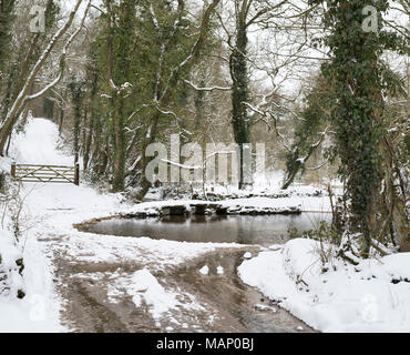 Ford e battaglio ponte in inverno la neve sul Fiume Windrush a Kineton. Kineton, Gloucestershire, Regno Unito Foto Stock