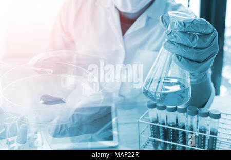 Vacutainer o tubo di test in laboratorio su tabella scienziato tenere il vetro ware Foto Stock