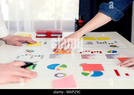 Colleghi di lavoro lavorare insieme e di analizzare i dati finanziari su un grafici. Il concetto di business, statistiche Foto Stock