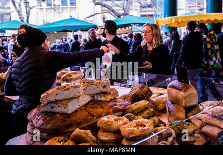 Donna acquistare alimenti da baker stallo, Borough Market, Southwark, Londra, Inghilterra, Regno Unito Foto Stock