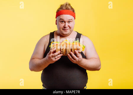 Uomo felice preparare da mangiare hamburger e guardare la fotocamera Foto Stock