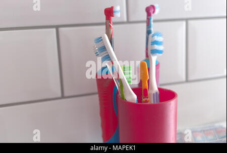 Una varietà di spazzolini da denti, inclusi gli spazzolini da denti elettrici in un ambiente bagno Foto Stock