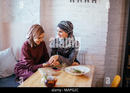 Due donne musulmane in cafe, riunione amici Foto Stock