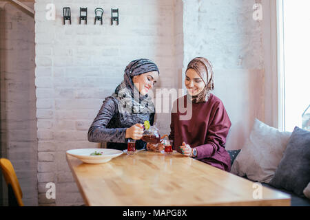 Due caucasica donna musulmana bere il tè in cafe Foto Stock