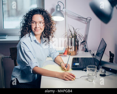 Vista laterale foto della bella ragazza facendo ricerca sul computer portatile Foto Stock