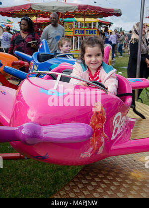 Un giovane bambino corse su una fiera Merry Go Round Foto Stock