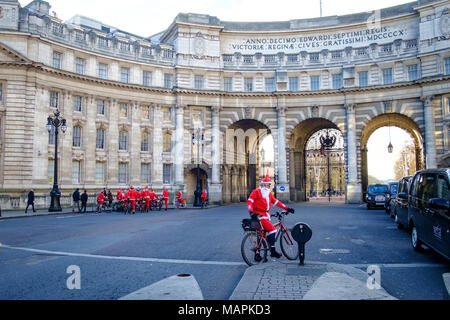 Londra, Inghilterra 21 Dicembre 2017: Santa ciclisti nella carità Ride through Admiralty Arch a Londra Foto Stock