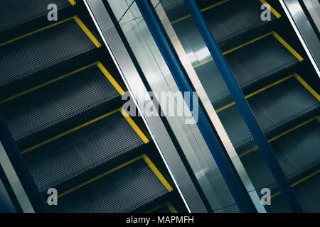 Escalator closeup: due scale di metallo con parapetto in vetro tra di essi Foto Stock
