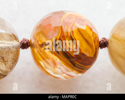 Le riprese in modalità macro di minerale naturale campione di roccia - tallone da quarzo fumè pietre preziose su marmo bianco bac Foto Stock