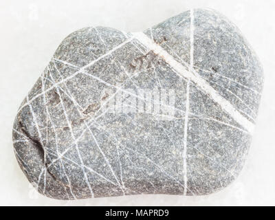 Le riprese in modalità macro di minerale naturale campione di roccia - Grovacca arenaria bianca su sfondo marmo Foto Stock