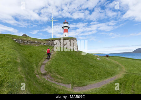 L'uomo cammina al faro e la storica fortezza di Skansin,Torshavn, Streymoy Isola, Isole Faerøer, Danimarca, Europa Foto Stock