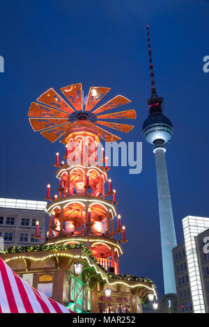 La piramide di Natale al mercatino di Natale di Alexanderplatz con la Fernsehturm torre televisiva dietro, Berlin-Mitte, Berlino, Germania, Europa Foto Stock