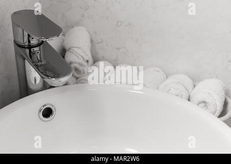 Bagno interno con elegante dissipatore di bianco. Asciugamani Viso vicino al lavandino Foto Stock