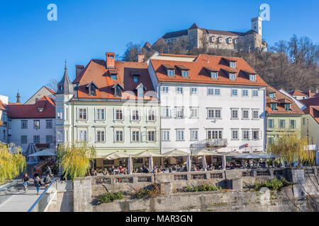 Vista di edifici lungo il fiume Ljubljanica e Castello visibile in background, Lubiana, Slovenia, Europa Foto Stock