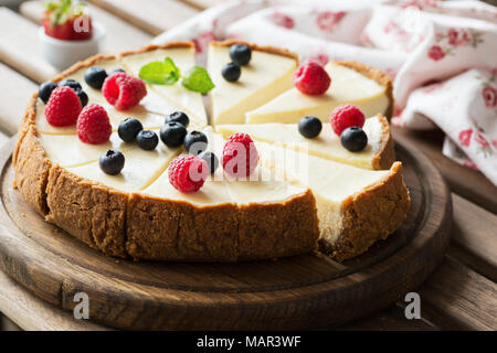 La peste Cheesecake con frutti di bosco freschi sulla tavola di legno, fuoco selettivo, composizione orizzontale Foto Stock