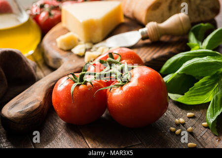 Tomatoes on vine, olive oil and parmesan cheese. Italian food background or still life Foto Stock