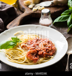 La pasta italiana con salsa di pomodoro e gamberetti su piastra bianca, vista cloeup, quadrato ritaglia Foto Stock