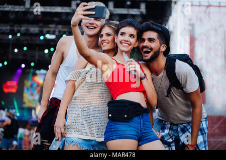 Happy amici prendendo selfie presso il festival di musica Foto Stock