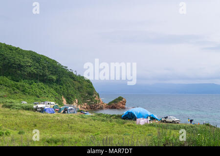 Un campeggio turistico sulle rive della pittoresca baia di Putyatin isola nel Territorio di Primorskij. Persone appoggiano nel bivacco turistica di tende Foto Stock