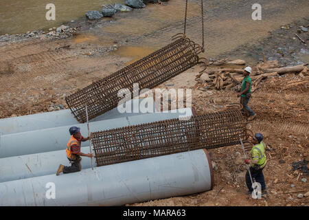 UTUADO, Puerto Rico, Gennaio 31, 2018--una gru solleva un rebar caso che sarà installato in un riscontro da parte del Rio Abajo bridge lavori di fondazione. Una intera comunità che è stata tagliata fuori dalla strada principale dalle acque di esondazione dall uragano Maria che ha distrutto il ponte originale, beneficeranno della ricostruzione. Questo progetto dovrebbe essere completato a metà marzo. FEMA/Eduardo Martinez Foto Stock