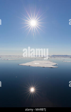 Il sole di mezzanotte oltre l'Oceano Artico. Nordaustland, Svalbard, Norvegia. Foto Stock