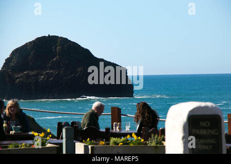 Turisti che si godono il pranzo presso un pub con un mare vista oceano a Trebarwith Strand in Cornovaglia, Inghilterra Foto Stock