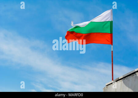 Bandiera bulgara agitando contro vibrante blu cielo Foto Stock